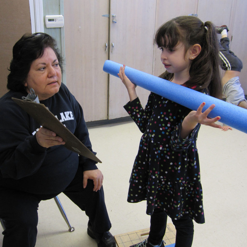 woman showing a paper document to a child